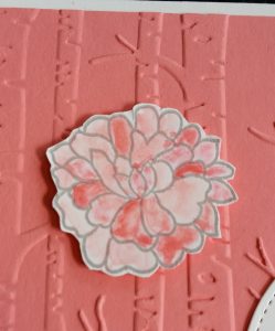 Die Blüte aus dem Stempelset "Für immer" wurde mit Flamingorot koloriert und auf den Untergrund geklebt.